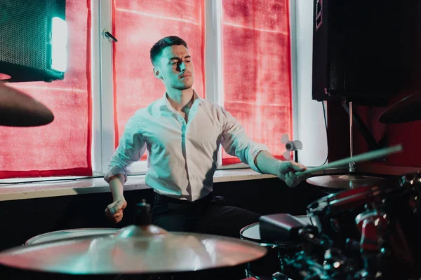 Yakışıklı adam konsere hazırlanırken davul çalıyor.