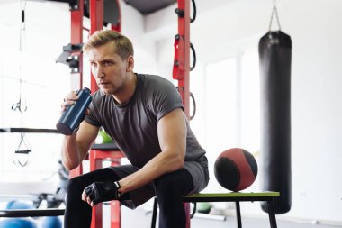 Spor yaparken su içen adam.