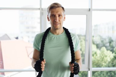 Genç sporcu, geniş bir alanda iple antrenman yapıyor.