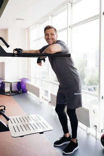 Retrato de um homem mucular no ginásio de fitness olhando para a câmera. — Fotografia de Stock