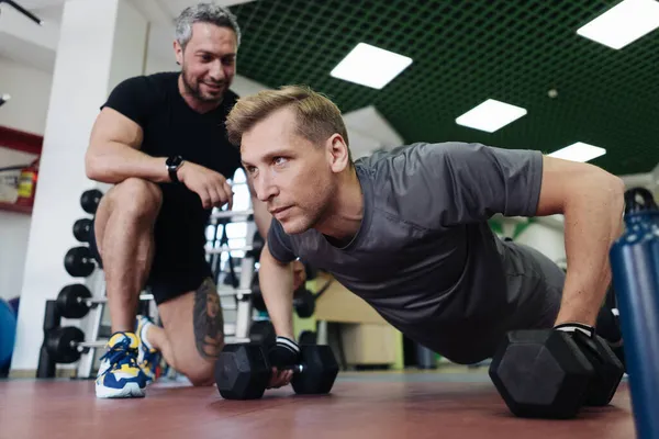 Jovem tem treino com personal trainer no ginásio — Fotografia de Stock