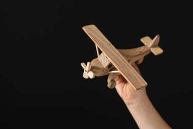 Elinde siyah arka planda bir uçak modeli tutuyordu.