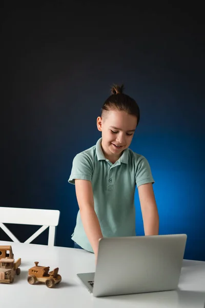 Niño usando el ordenador portátil en el escritorio en casa — Foto de Stock