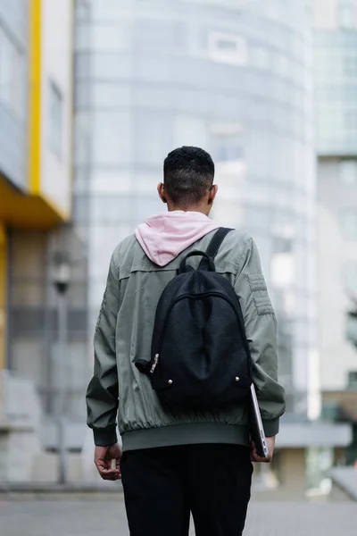 Anak muda mengenakan jaket dan ransel luar ruangan memegang laptop — Stok Foto