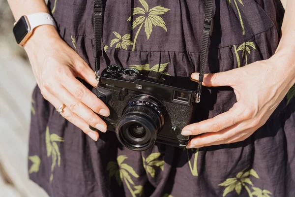 Close up Fotokamera in Frau Hände auf Kleid Hintergrund — Stockfoto