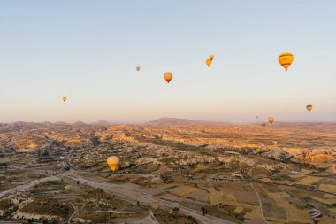 Türkiye 'nin Kapadokya kentindeki beyaz dağların tepesinde uçan sıcak hava balonu