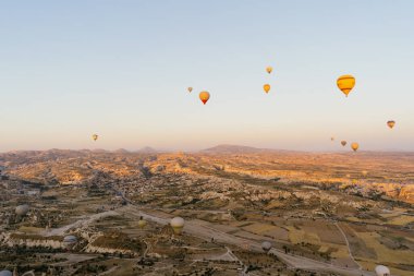Türkiye 'nin Kapadokya kentindeki beyaz dağların tepesinde uçan sıcak hava balonu
