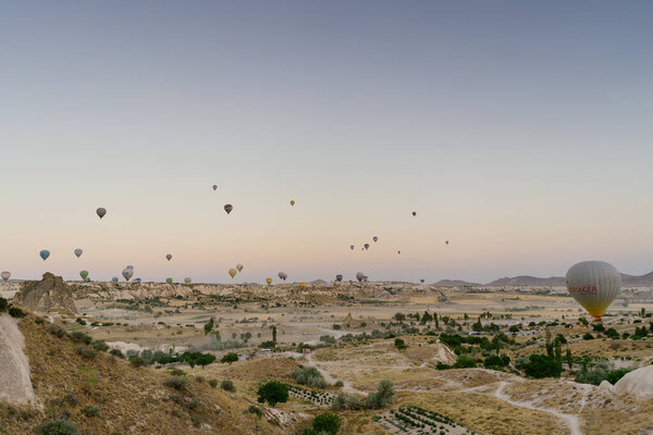 Flying hot air balloon on the top of white mountains in Cappadocia, Turkey