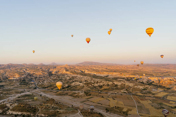 Flying hot air balloon on the top of white mountains in Cappadocia, Turkey