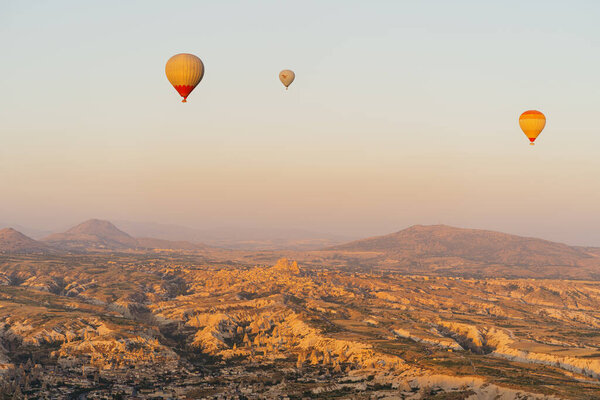 Flying hot air balloon on the top of white mountains in Cappadocia, Turkey