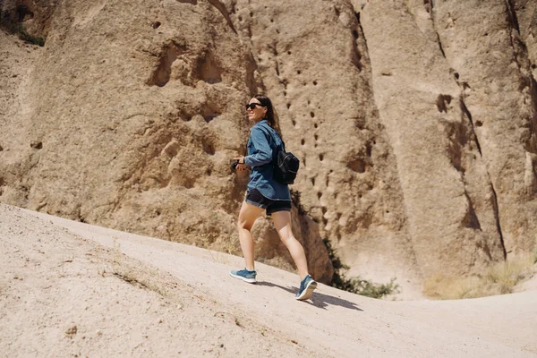 Junge Wanderin mit Rucksack wandert in felsigem alten Gebirge — Stockfoto