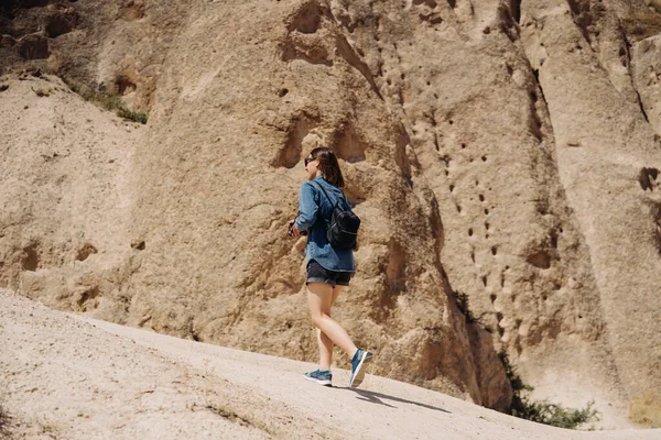 Junge Wanderin mit Rucksack wandert in felsigem alten Gebirge — Stockfoto