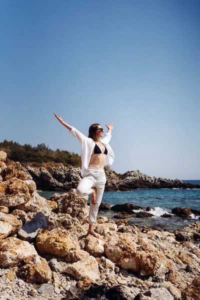 Traveler donna gode la sua vacanza sulla costa del mare praticando yoga — Foto Stock