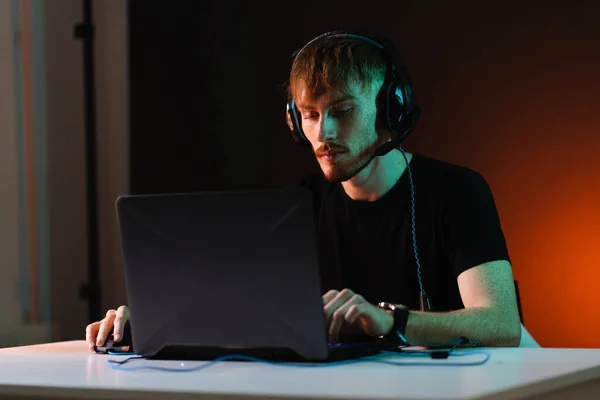 Gamer jogar jogos de vídeo com fones de ouvido no fundo de luz de néon — Fotografia de Stock