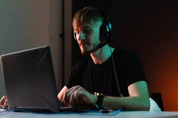 Gamer jogar jogos de vídeo com fones de ouvido no fundo de luz de néon — Fotografia de Stock