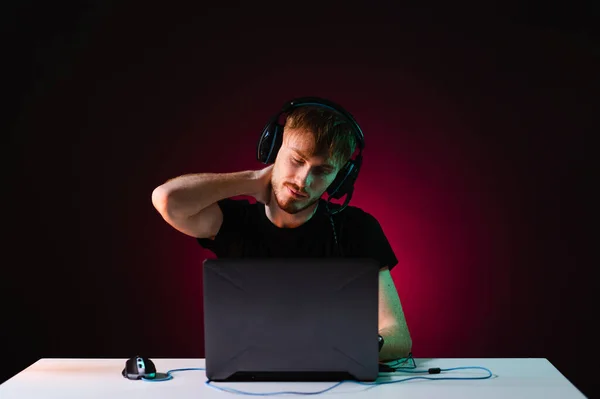 Neon ışıklı arka planda kulaklıkla video oyunu oynayan oyuncu — Stok fotoğraf