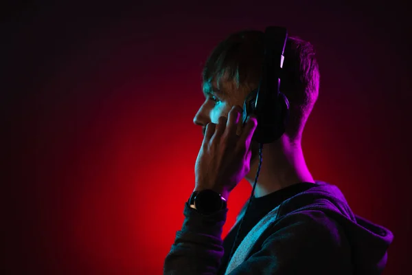 Portret van een man met een koptelefoon in neonlicht — Stockfoto
