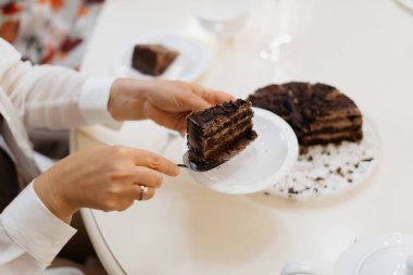 Kadın elleri pasta kesiyor ve servis yapıyor.