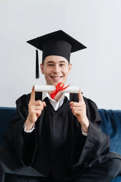 Beyaz tenli genç adam bekarlık diplomasını aldığı için çok heyecanlı. — Stok fotoğraf