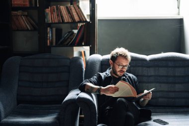 Yetişkin öğrenci üniversite kütüphanesinde kitap okuyor.