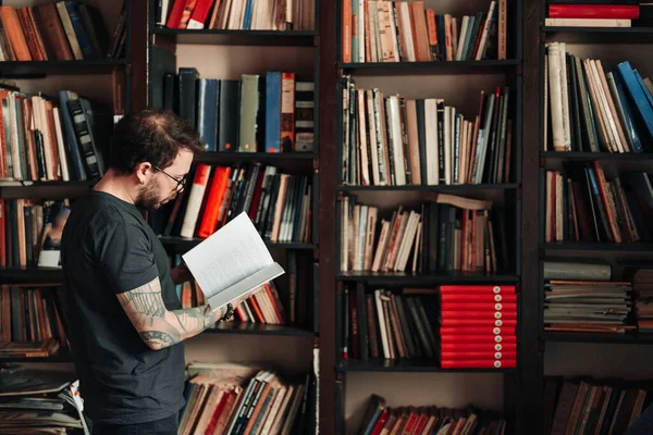 Estudante adulto lendo um livro na biblioteca da faculdade — Fotografia de Stock