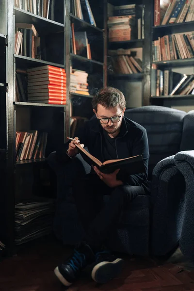 Erwachsener Student liest während des Rauchens ein Buch in der Universitätsbibliothek — Stockfoto