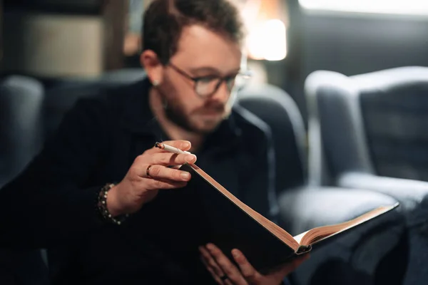 Felnőtt diák olvas egy könyvet a főiskolai könyvtár dohányzás közben — Stock Fotó