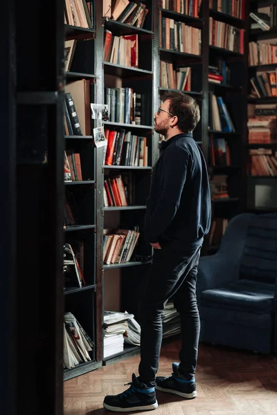 Estudiante adulto mirando por un libro en la biblioteca de la universidad — Foto de Stock