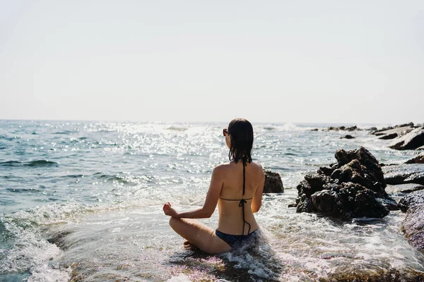 Traveler donna gode la sua vacanza sulla costa del mare praticando yoga — Foto Stock