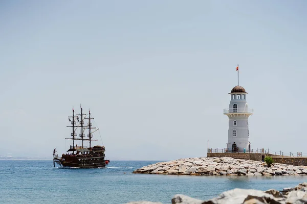 Живописный вид на пристань Алания с маяком и кораблем в море — стоковое фото