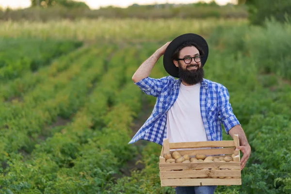 Rolnik trzymający drewnianą skrzynkę ziemniaków — Zdjęcie stockowe