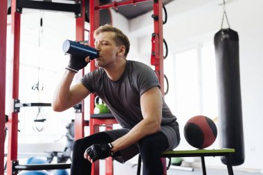 Spor yaparken su içen adam.