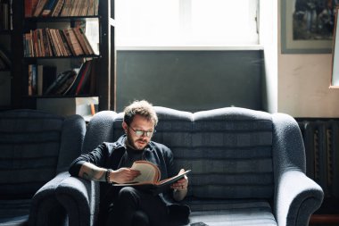 Yetişkin öğrenci üniversite kütüphanesinde kitap okuyor.