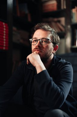 Arkaplanda kitaplar olan insan portresi