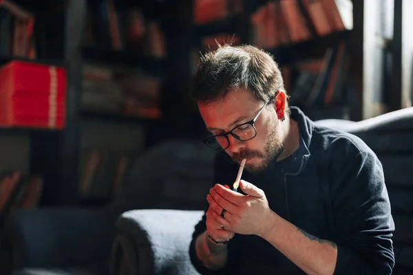 Hombre Fumador retrato con libros en el fondo — Foto de Stock