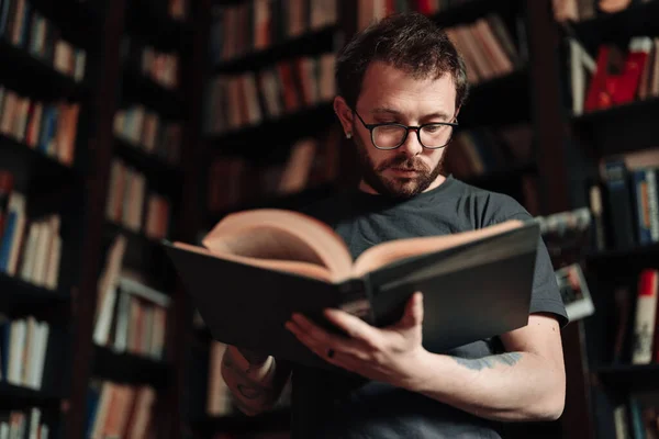 Studente adulto che legge un libro nella biblioteca del college — Foto Stock