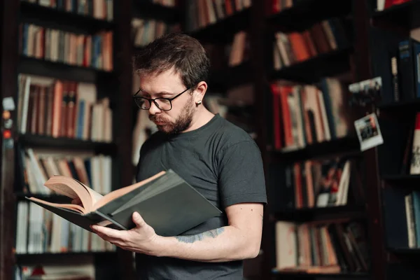Studente adulto che legge un libro nella biblioteca del college — Foto Stock