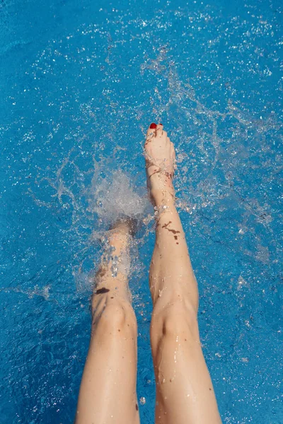 女は暖かい夏の日に水に足を振りかける — ストック写真