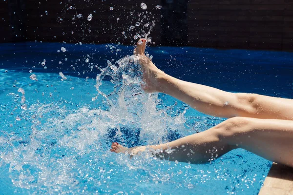 Vrouw spettert haar voeten in het water op warme zomerdag — Stockfoto