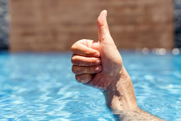Férfi kéz jeleit mutatja a medencében — Stock Fotó