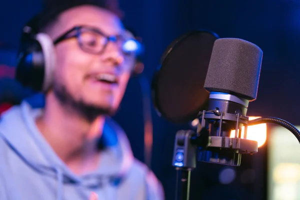 Joven cantante masculino en estudio de grabación actuando en luces de neón —  Fotos de Stock