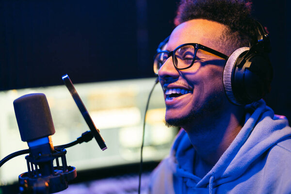 Young male singer in recording studio performing in neon lights
