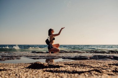 Cheerful young woman enjoying freedom on vacation on the sea side