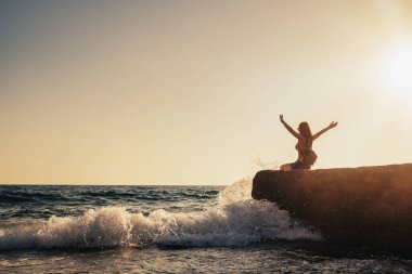 Beautiful young woman enjoying freedom on vacation on the seaside