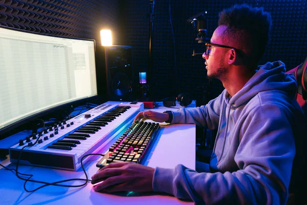 Producer, audio engineer uses a control panel and screen to record a track of a new album in a recording studio, in a soundproof room. Image producer, designer in working process