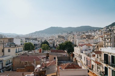 KAVALA, GREECE - 7 Temmuz 2022: Beyaz evler ve ufukta mavi gökyüzü, Kavala
