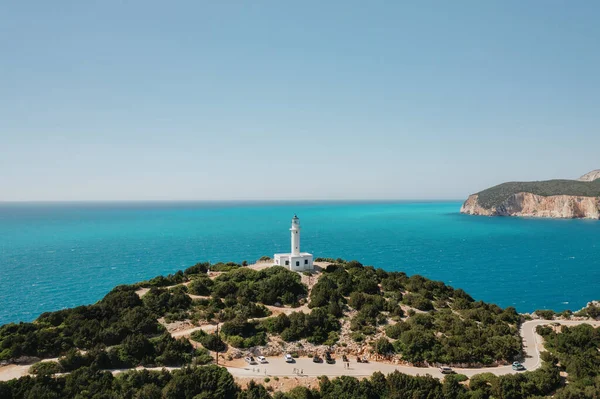ギリシャのターコイズブルーの澄んだ水と木の海と灯台で見る — ストック写真