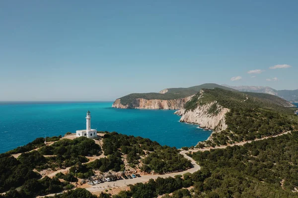 ギリシャのターコイズブルーの澄んだ水と木の海と灯台で見る — ストック写真