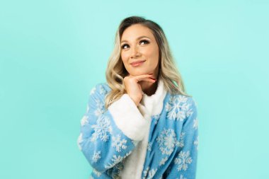 Güzel elbiseli, kar bakiresi, mavi arka planda makyajlı hoş bir kadın.