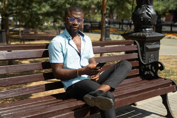 Odpoczynku Afrykański Człowiek Ławce Telefonu Komórkowego — Zdjęcie stockowe